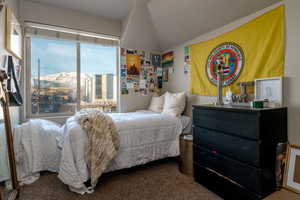 Bedroom featuring carpet, lofted ceiling, and a mountain view