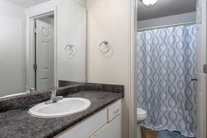 Bathroom with toilet, tile patterned flooring, and vanity