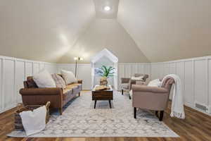 Living room featuring vaulted ceiling and hardwood / wood-style flooring