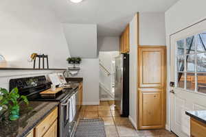 Kitchen featuring dark granite counters, sink, and stainless steel appliances