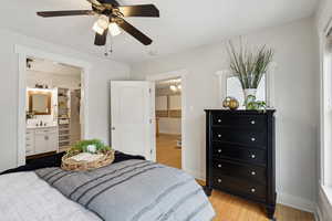 Primary Bedroom featuring a spacious closet, bamboo wood-style floors, sink, ceiling fan, and ensuite bathroom