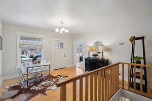 Entrance foyer featuring light bamboo wood-style floors and an inviting chandelier