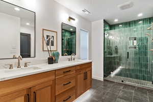 Bathroom featuring a textured ceiling, a shower with shower door, and vanity