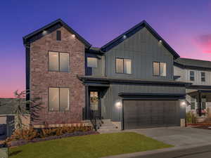 View of front facade featuring a yard and a garage