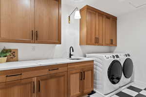 Washroom with cabinets, separate washer and dryer, and sink