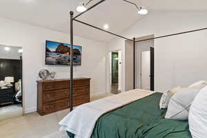 Bedroom with vaulted ceiling and light carpet