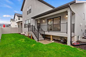 Rear view of property with a yard