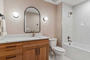 Full bathroom featuring tile patterned floors, tiled shower / bath combo, vanity, and toilet