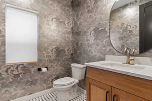 Bathroom featuring toilet, vanity, and tile patterned flooring