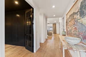 Hallway featuring a chandelier and light hardwood / wood-style flooring