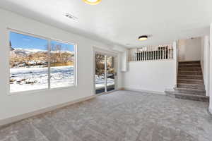 Unfurnished living room featuring a mountain view and carpet floors