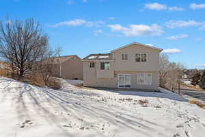 View of snow covered back of property