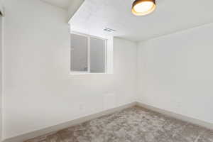 Carpeted spare room with a textured ceiling