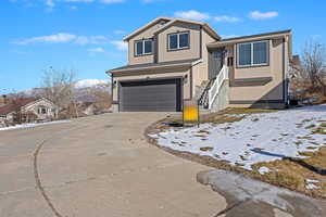 View of front of house with a mountain view and a garage