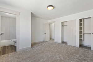 Unfurnished bedroom featuring connected bathroom and carpet flooring