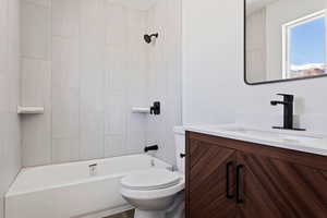 Full bathroom with toilet, vanity, and tiled shower / bath