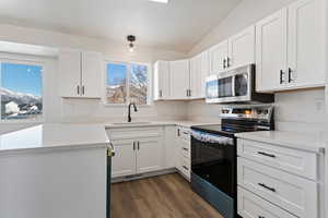 Kitchen featuring appliances with stainless steel finishes, dark hardwood / wood-style flooring, white cabinetry, and sink