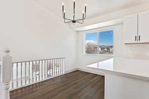 Unfurnished dining area featuring dark hardwood / wood-style floors and a chandelier