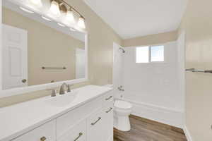 Upstairs - Full bathroom featuring toilet, vanity, wood-type flooring, and shower / bathing tub combination