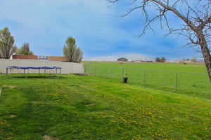 View of yard with a rural view and fence