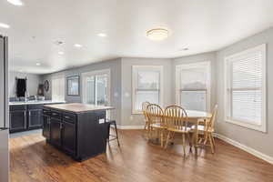 Kitchen featuring hardwood style floors, barn sink, a kitchen breakfast bar