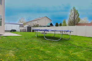 View of yard featuring a patio, a fenced backyard, an outdoor structure, and a shed