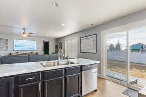 Kitchen featuring a wealth of natural light, dishwasher, barn sink, and hardwood flooring