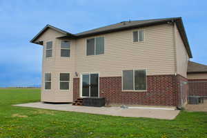 Rear view of house featuring central AC unit, a patio area, fence, a yard, and entry steps
