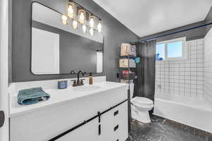 Full bathroom with toilet, shower / tub combo, and vanity