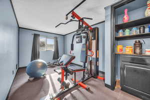 Exercise room featuring a textured ceiling and ornamental molding