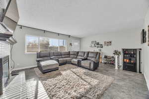 Living room with a brick fireplace and a textured ceiling