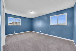 Carpeted spare room with a textured ceiling