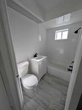 Full bathroom featuring toilet, tiled shower / bath combo, and vanity