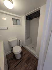 Bathroom with wood-type flooring, quartz countertops, and tiled shower