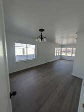 Dining room w/ dark LVP flooring, crown molding, and a notable chandelier