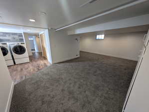 Basement featuring separate washer and dryer and dark colored carpet