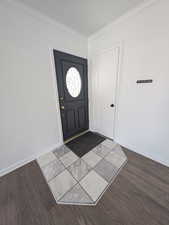 Foyer featuring crown molding and hardwood / wood-style flooring