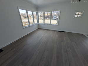 Living room with dark wood-style floors and large corner windows