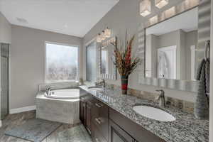 Bathroom featuring vanity and tiled tub