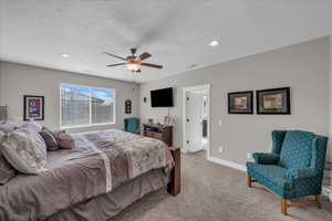 Carpeted bedroom with ceiling fan and a textured ceiling