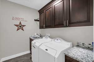 Laundry room with dark wood-type flooring, cabinets, independent washer and dryer, and sink