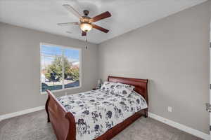 Carpeted bedroom featuring ceiling fan