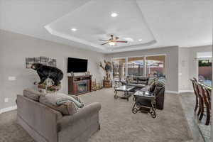 Living room with ceiling fan and a tray ceiling