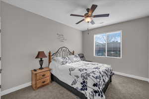 Bedroom with ceiling fan and light carpet