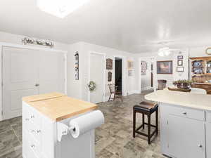 Kitchen featuring a kitchen breakfast bar, white cabinetry, a center island, and a skylight