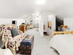 Bedroom with lofted ceiling and light colored carpet