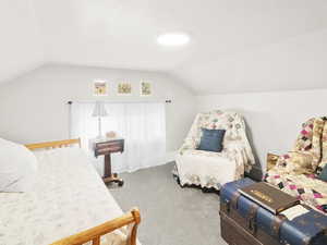 Carpeted bedroom with lofted ceiling