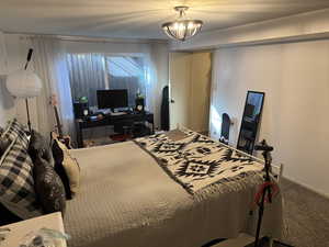 Bedroom with carpet floors and an inviting chandelier