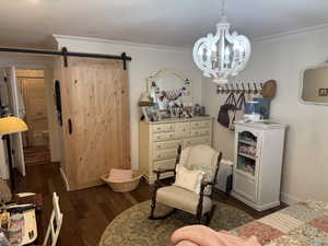 Living area with a barn door, engineered hard wood, crown molding, and a notable chandelier