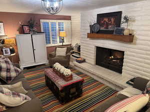 Living room with a textured ceiling, a fireplace.